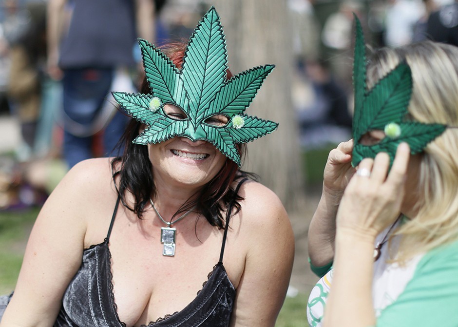 Women wear marijuana leaf masks at a 4/20 marijuana holiday in Civic Center Park in downtown Denver, Colorado. 