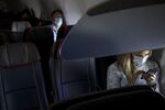 Passengers wear protective masks sit on a Boeing Co. 737-800 during an American Airlines Group Inc. flight departing from Los Angeles International Airport (LAX).