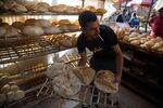 A worker arranges freshly baked bread for sale at the Al-Monira market in Cairo, Egypt.&nbsp;