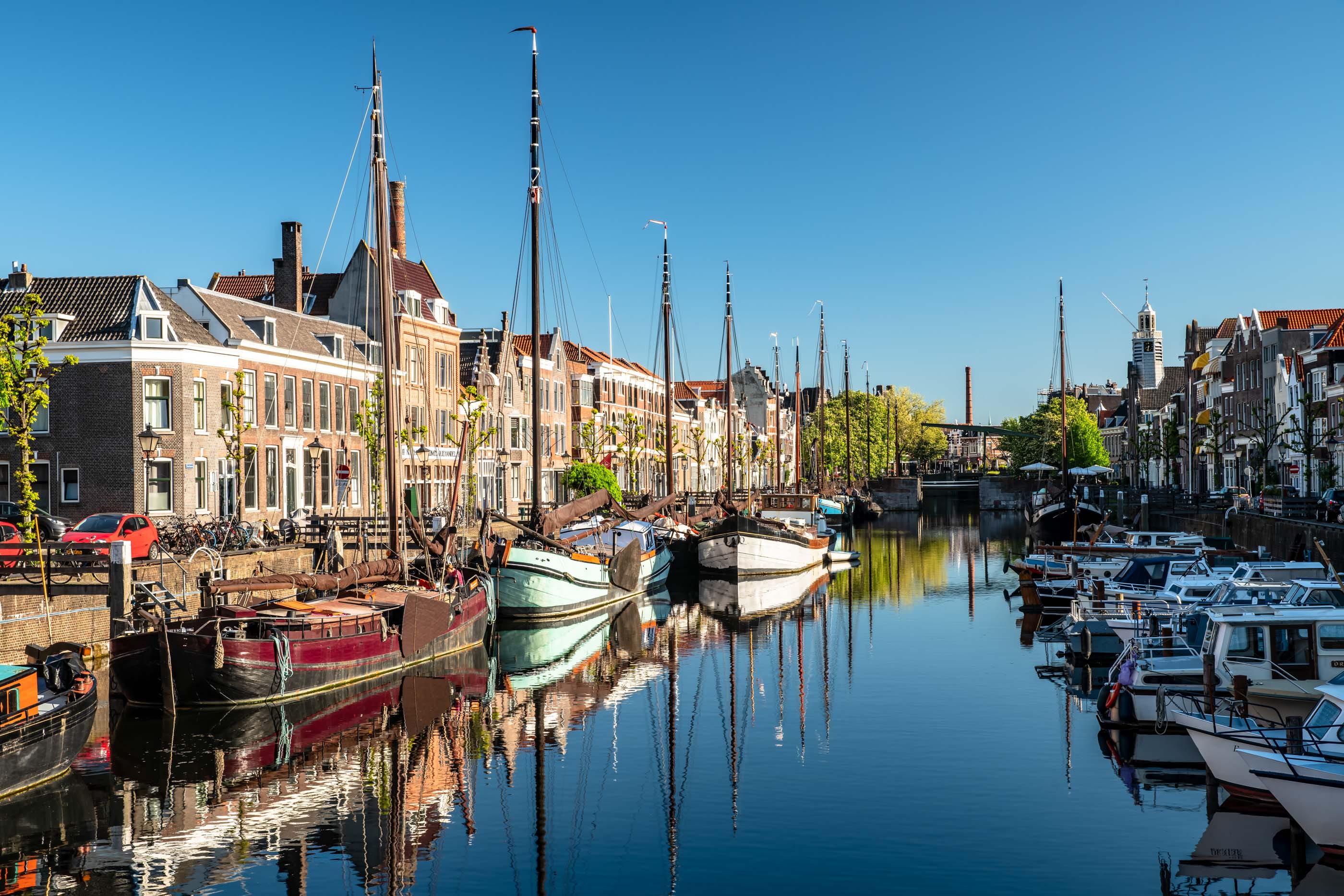 Boats and canal houses line the edge of the Maas river in the Delfshaven area of Rotterdam.