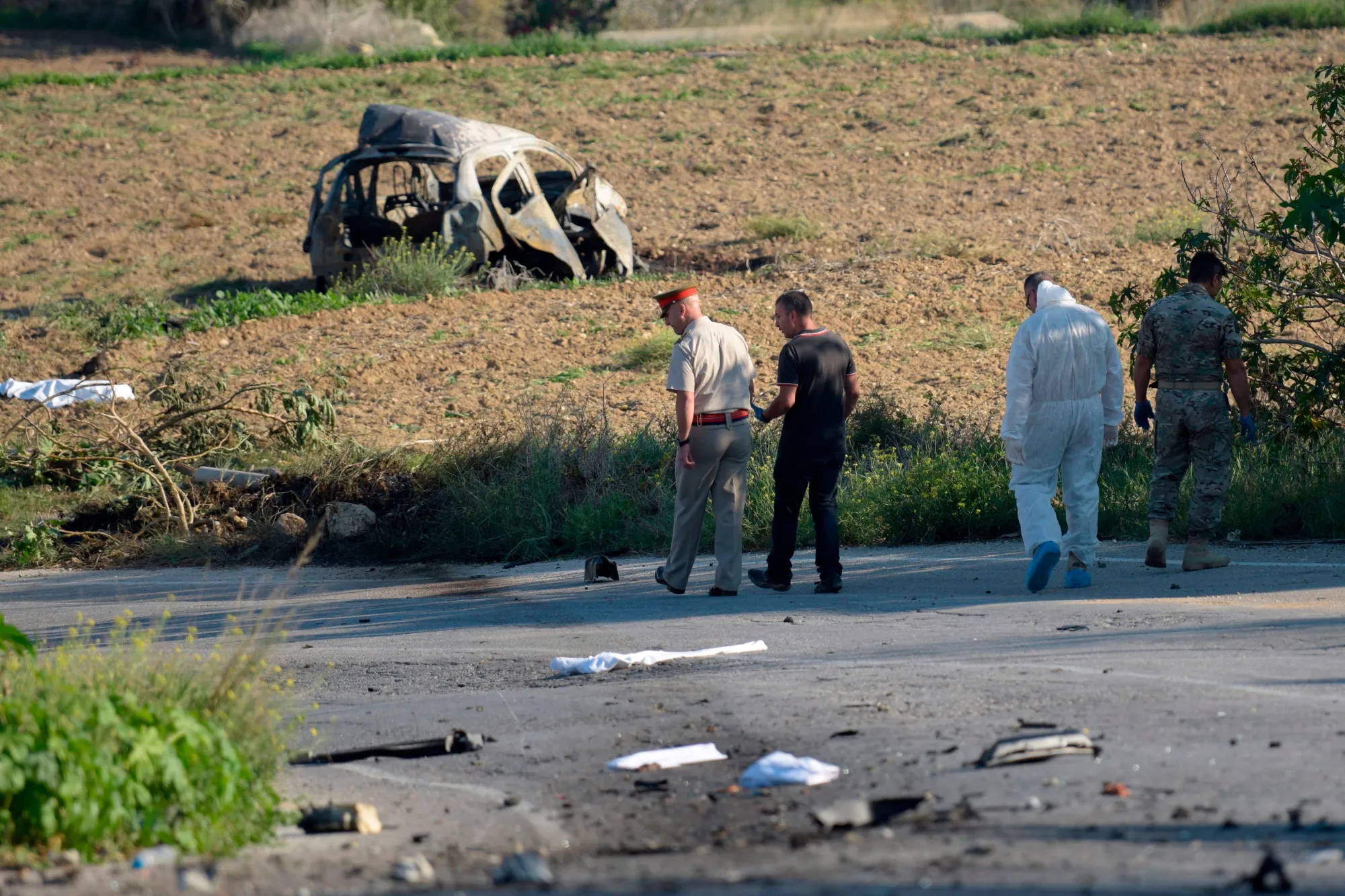 Police inspect the wreckage of murdered journalist Daphne Caruana Galizia’s car, in Bidnija, Malta, on Oct. 16.
