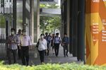 Pedestrians wearing protective masks walk past the Marina Bay Financial Centre in Singapore.