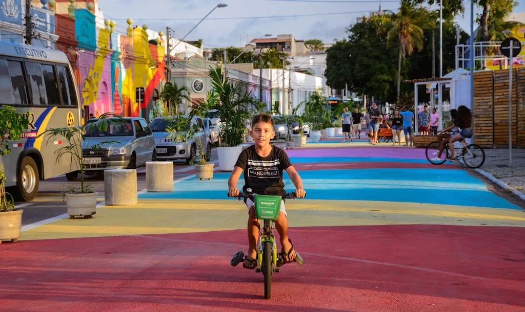 A child in Fortaleza, Brazil, rides his bike in a protected area of the street.