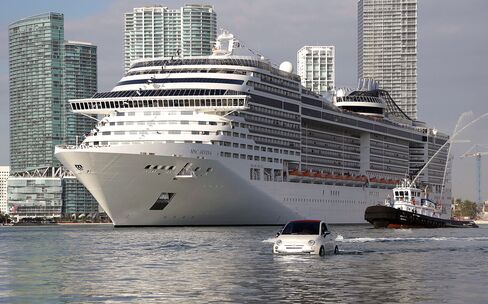 The MSC Divina cruise ship arrives at the Port of Miami escorted by a Fiat 500 watercraft, on Nov. 19, 2013.