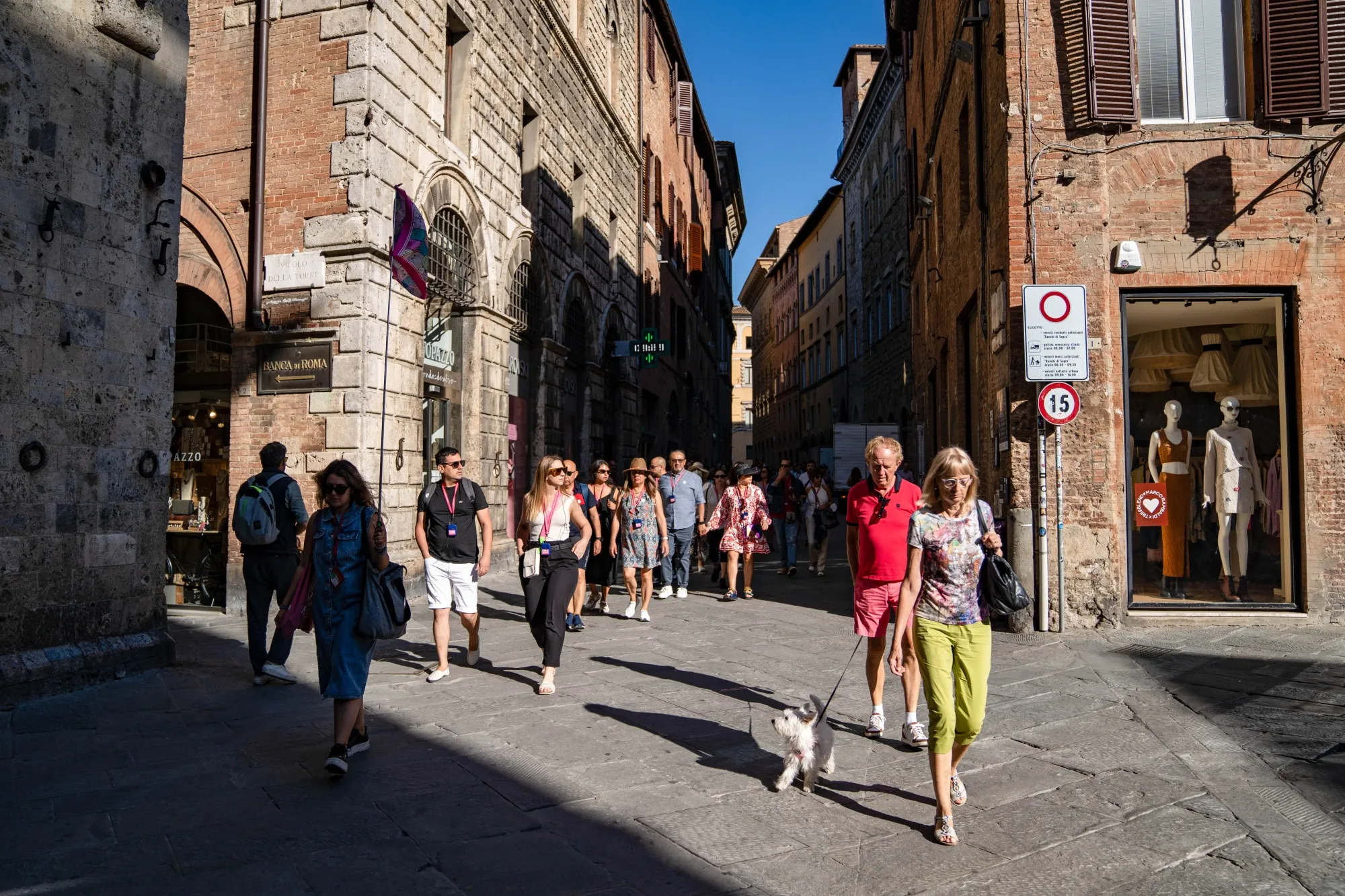 Tourists pass shops in central Siena, Italy.