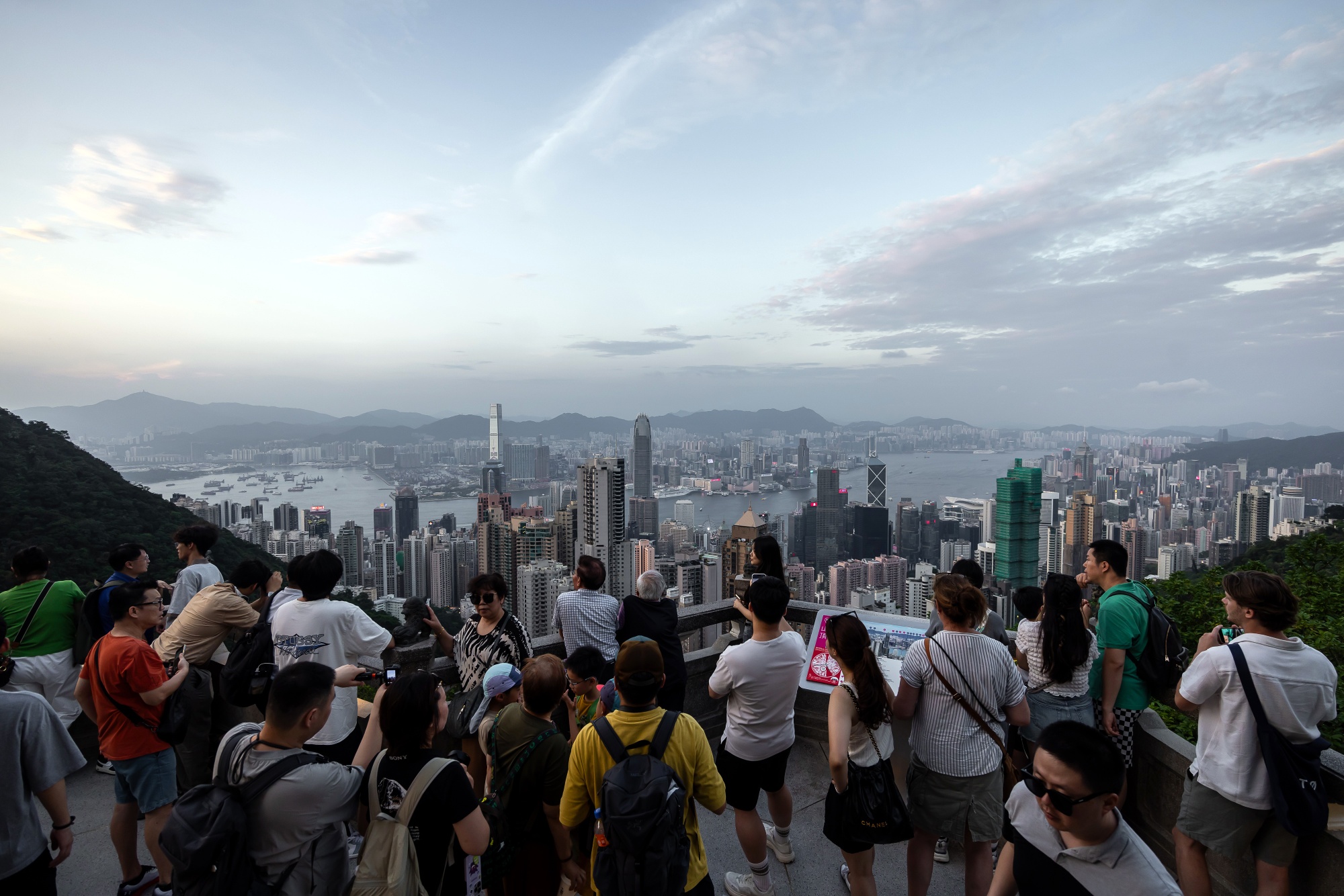 Visitors on the Sky Terrace 428 of the Peak Tower shopping mall on Victoria Peak in Hong Kong, China, on Friday, July 4, 2025. Hong Kong authorities intervened for the third time in a week to support the currency, which had dropped toward the weak end of its official trading band as the city’s interest rates touched a three-year low. Photographer: Paul Yeung&#x2F;Bloomberg