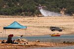 A CalFire helicopter practices water drops along Folsom Lake in Granite Bay, California, on June 16, 2021.