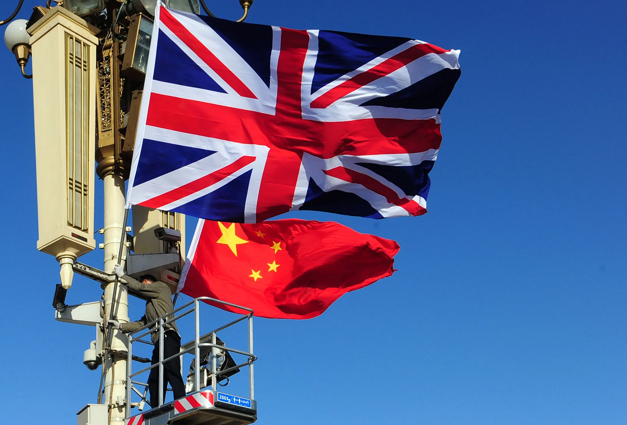 The Union Jack is hoisted next to the flag of the People's Republic of China
