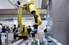 A Fanuc Inc. robotic arm operates to inspect a gear with the AI system, developed by Musashi Seimitsu Industry Co. and Abeja Inc., at the AI Expo - Artificial Intelligence Exhibition & Conference in Tokyo, Japan, on Wednesday, April 4, 2018.