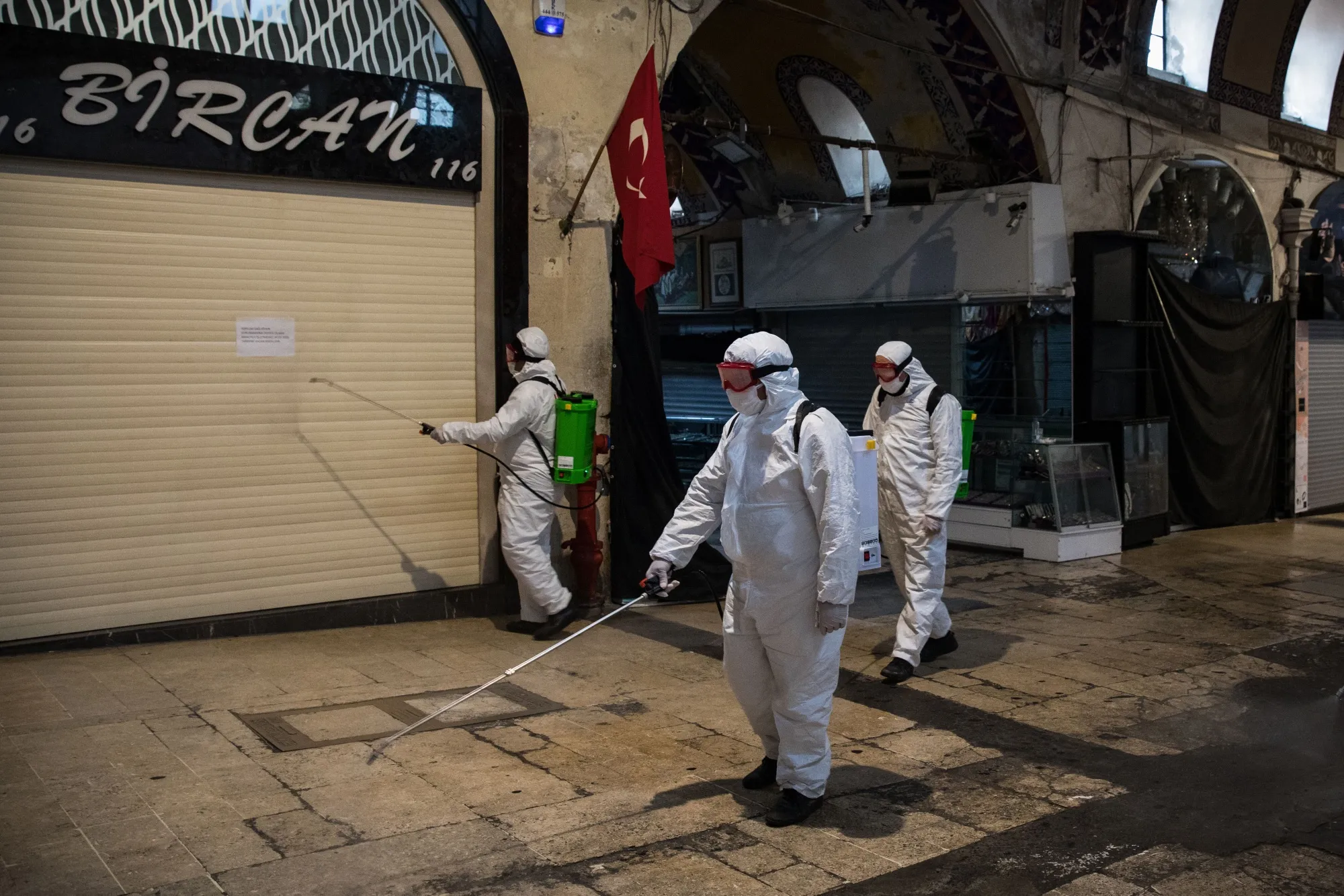 Members of the cleaning department spray disinfectant along a street inside the Grand Bazaar to prevent the spread of coronavirus in Istanbul on March 25.