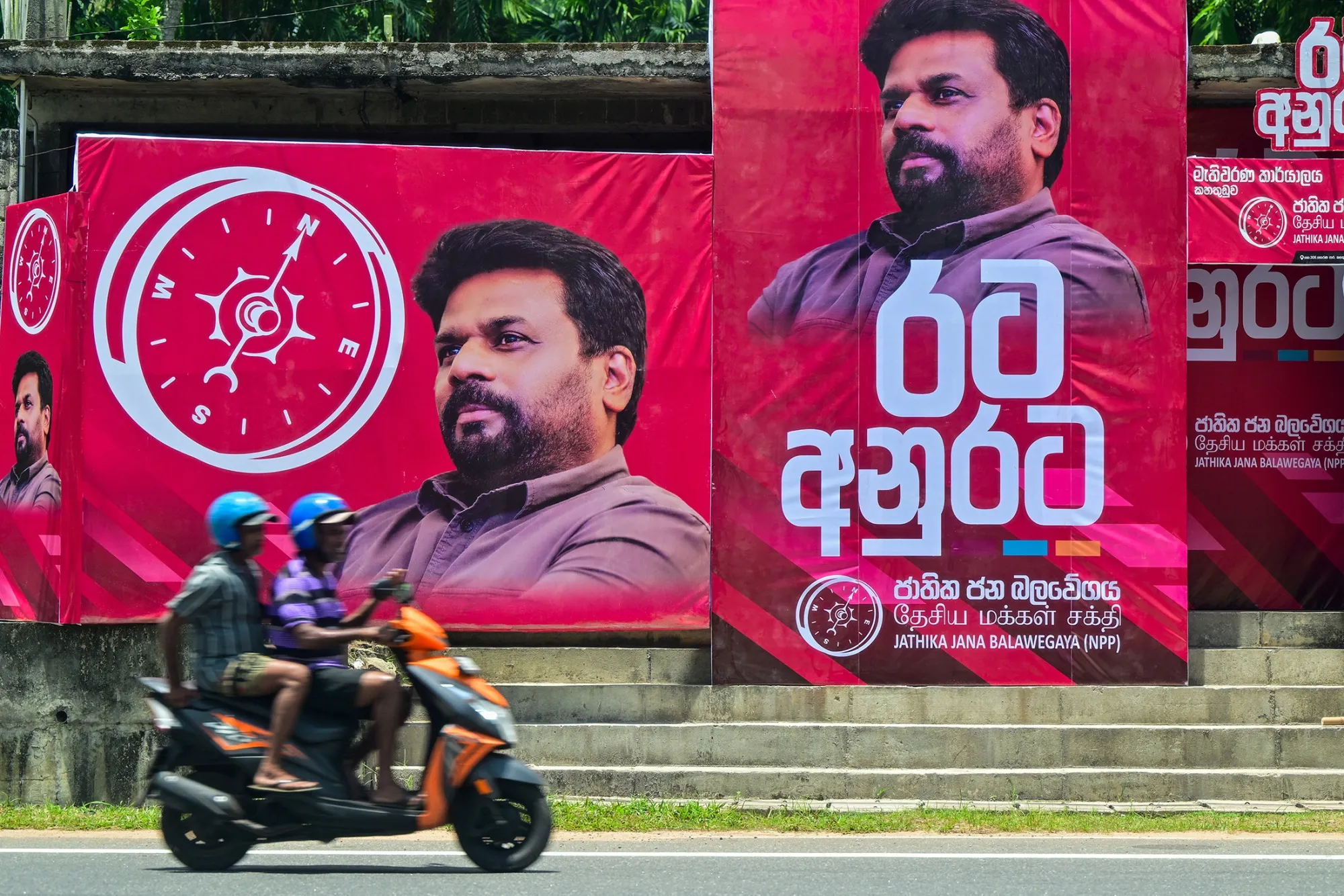 Motorists ride&nbsp;past posters of National People's Power&nbsp;presidential candidate Anura Kumara Dissanayake in Colombo.
