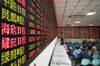 Investors stand at trading terminals in front of electronic stock boards at a securities brokerage in Shanghai, China, on Friday, Oct. 13, 2017. A number of economic indicators show "stabilized and stronger growth" and the momentum of a 6.9 percent expansion in the first six months of 2017 "may continue in the second half," People’s Bank of China Governor Zhou Xiaochuan said.