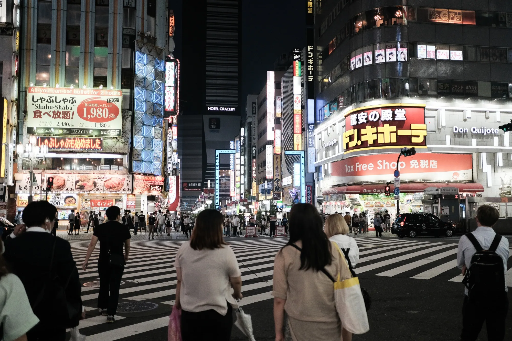Pedestrians wait to cross a street in the Shinjuku district of Tokyo, June 14.