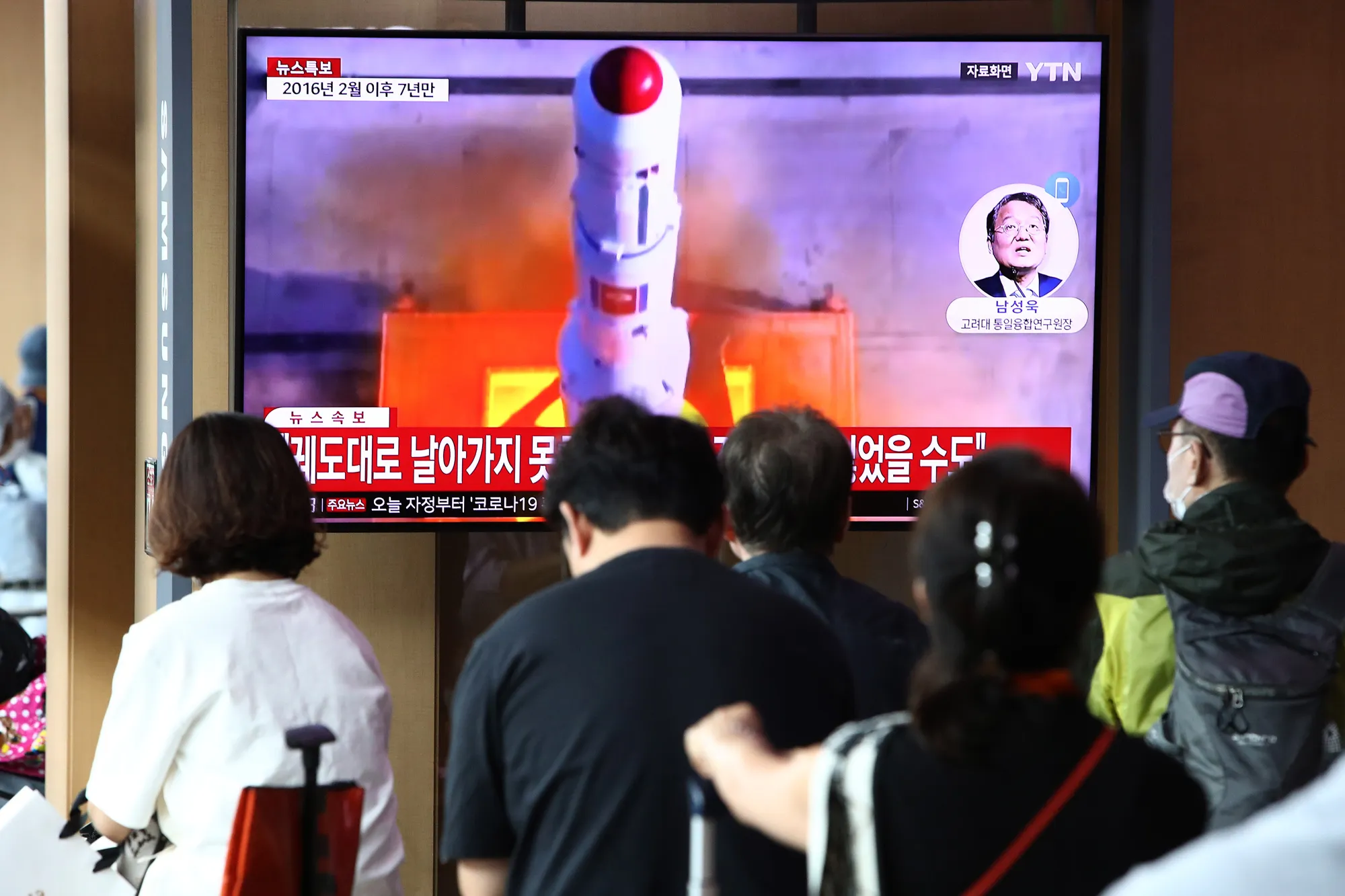 People watch a broadcast of a North Korean rocket launch, at the Seoul Railway Station in May.