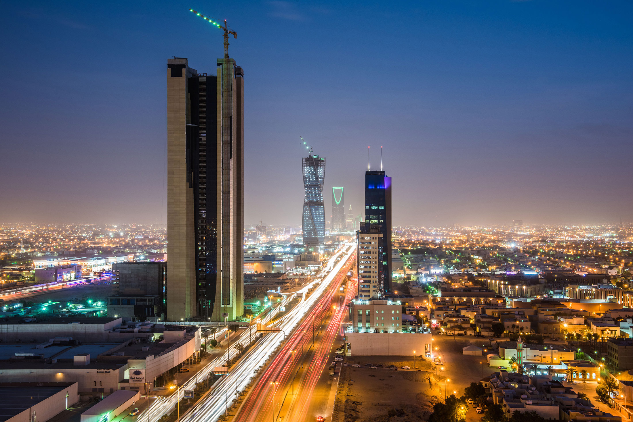 Light trails from traffic illuminate highways surrounded by residential buildings in Riyadh. Source Image: Bloomberg