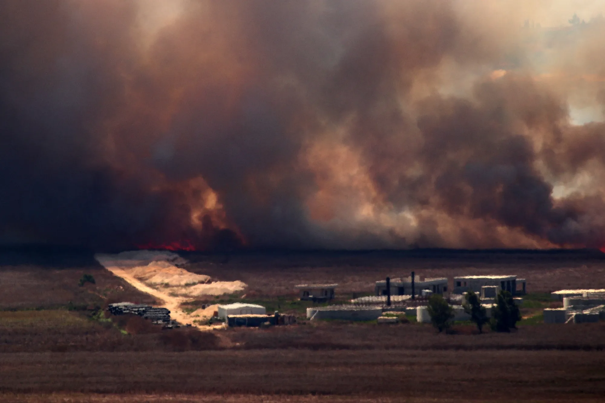 Fire sweeps over the Marjayoun plain in southern Lebanon near the border with Israel after being hit by Israeli shelling on August 16.