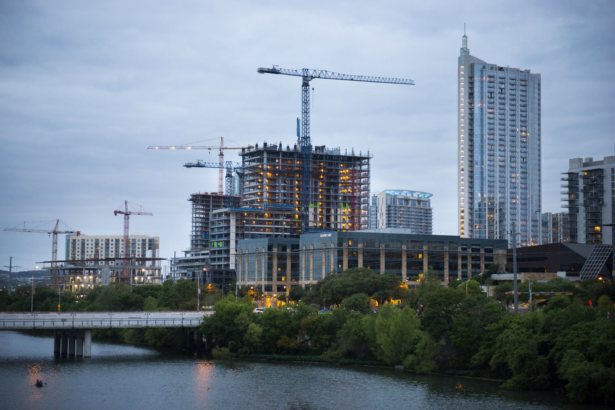 Construction cranes stand in the skyline of Austin, Texas.