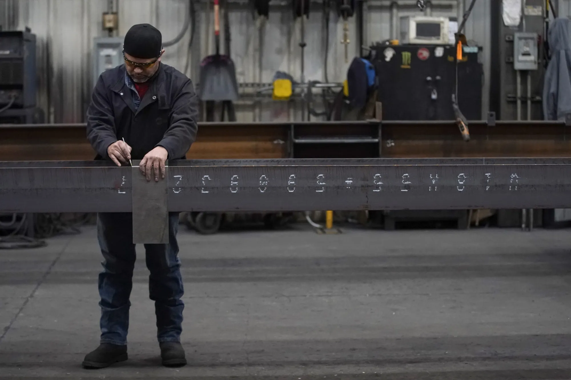 A worker marks an I-beam at a steel&nbsp;factory&nbsp;in West Jordan, Utah.