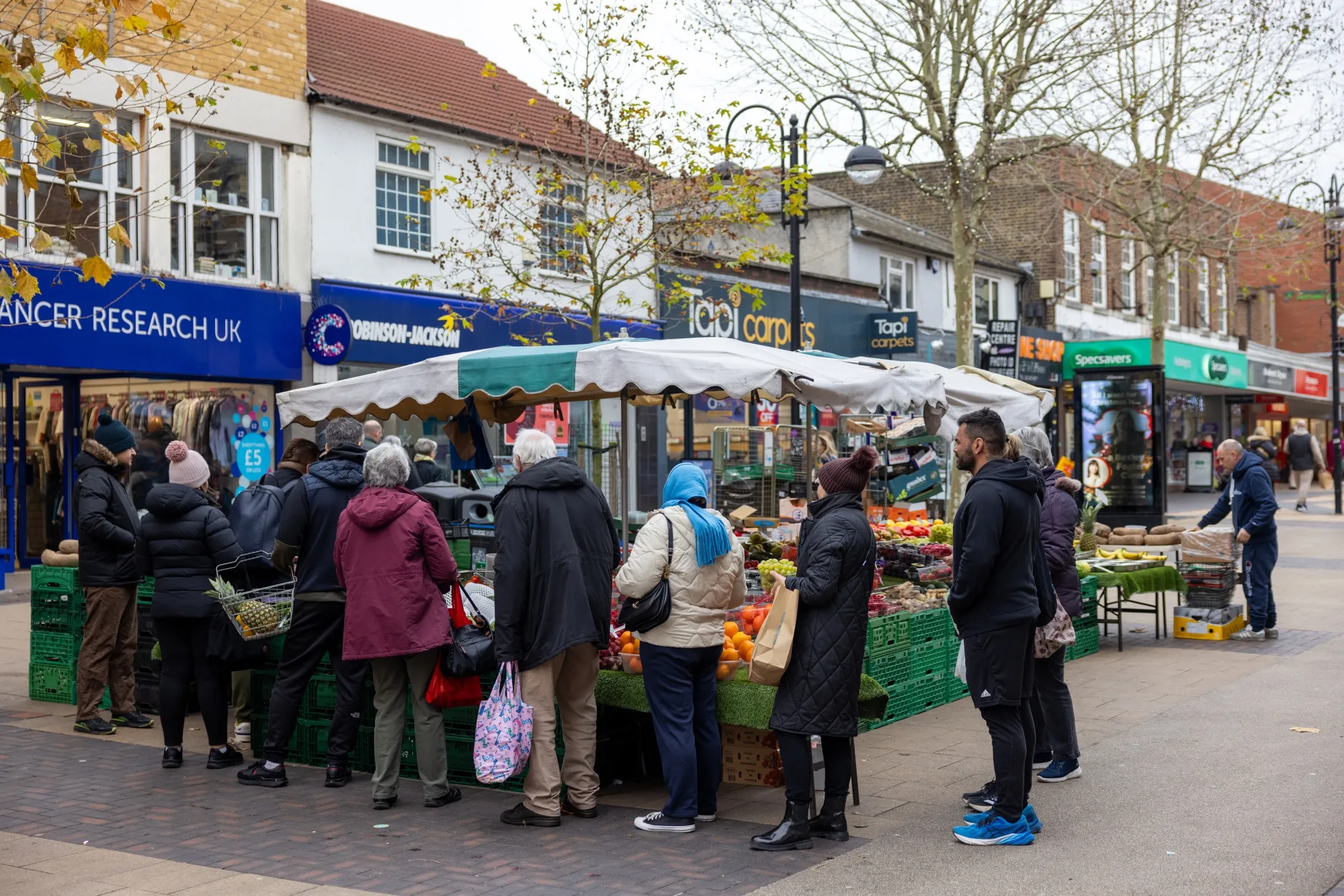 Shoppers queue at a fruit and vegetable stall in London, on Dec. 18.