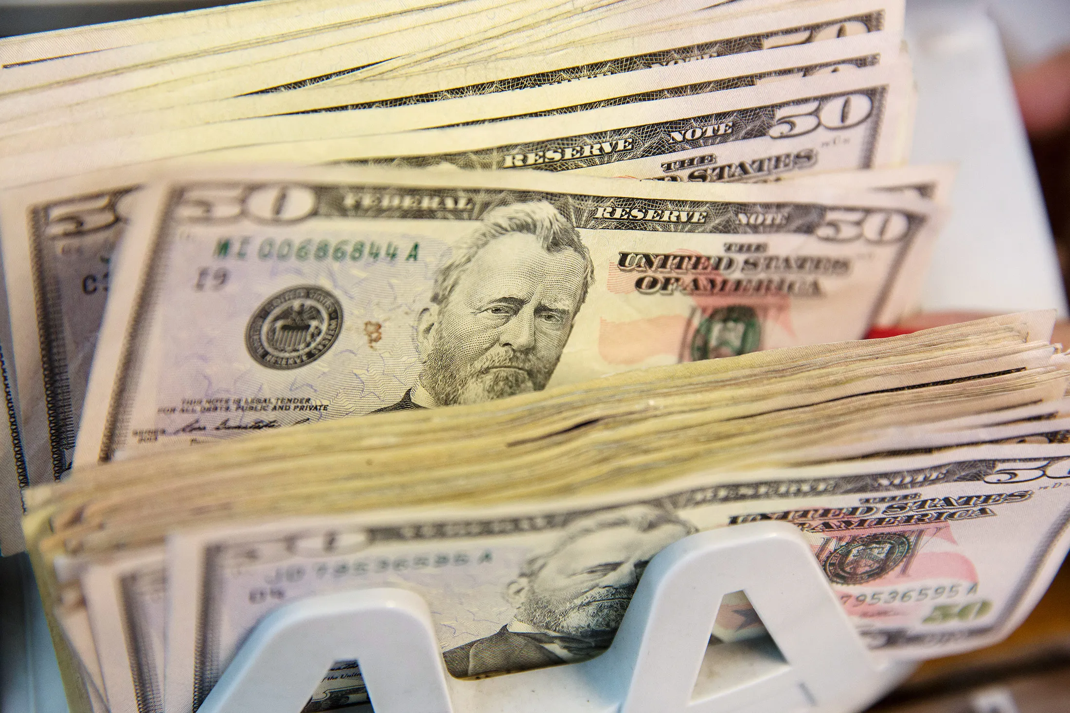 Fifty U.S bills are run through a counting machine at a currency exchange house in Mexico City.
