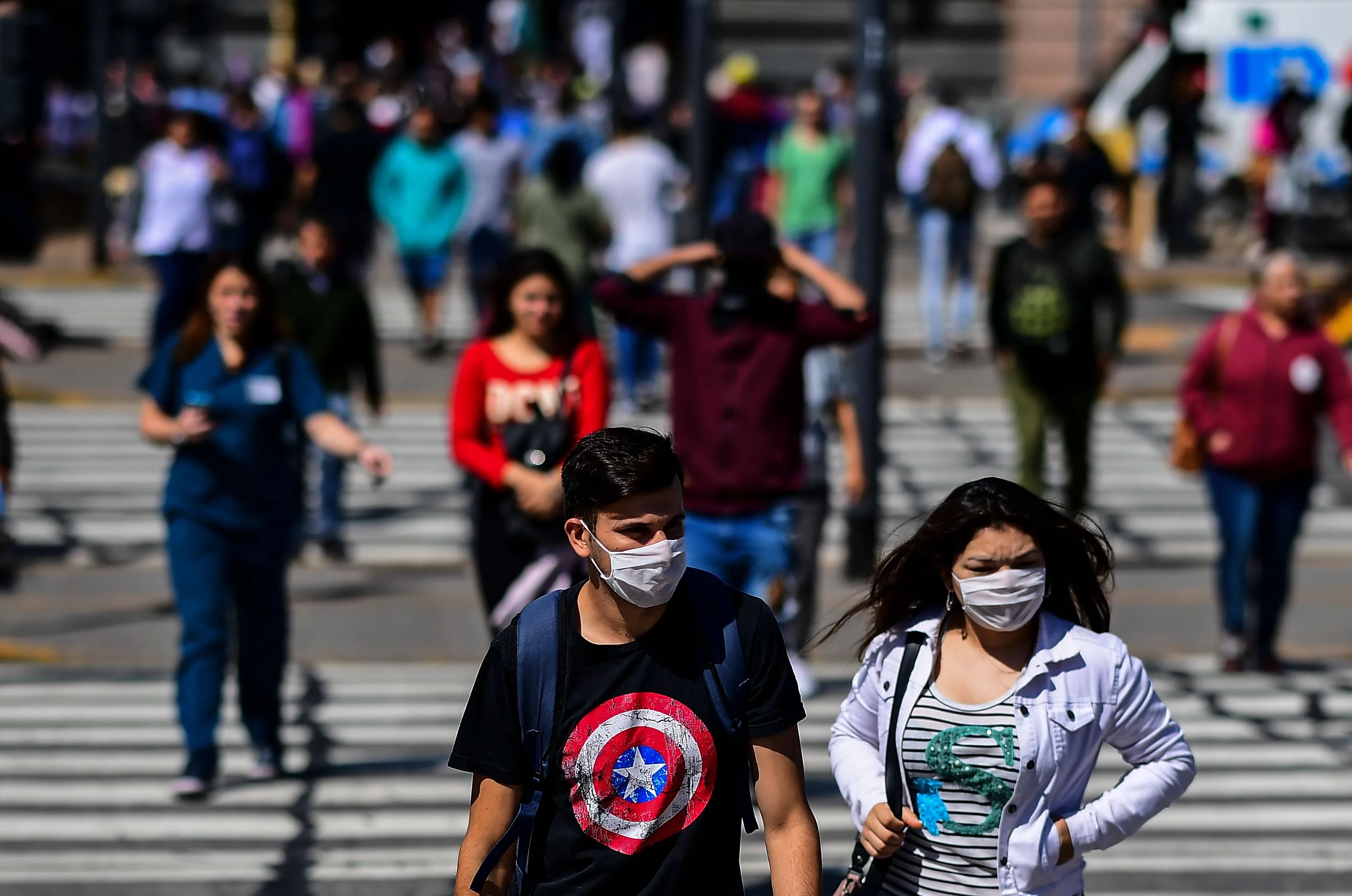 People cross a street outside Constitucion train station in Buenos Aires, on March 19.