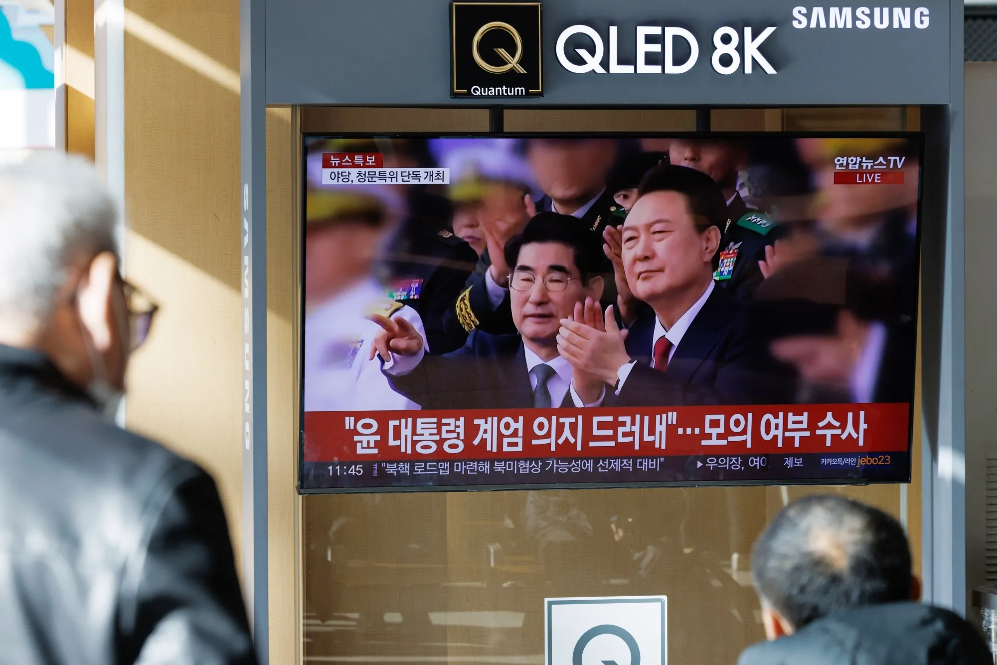 A screen displays a news report on South Korean President Yoon Suk Yeol at Seoul Station.