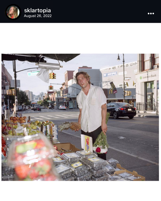 Screenshot of an Instagram post made by Ben Sklar on August 26, 2022. The image features Jeremy Allen White holding fresh flowers and produce in his hand with a cigarette in his mouth in a wide angle shot.
