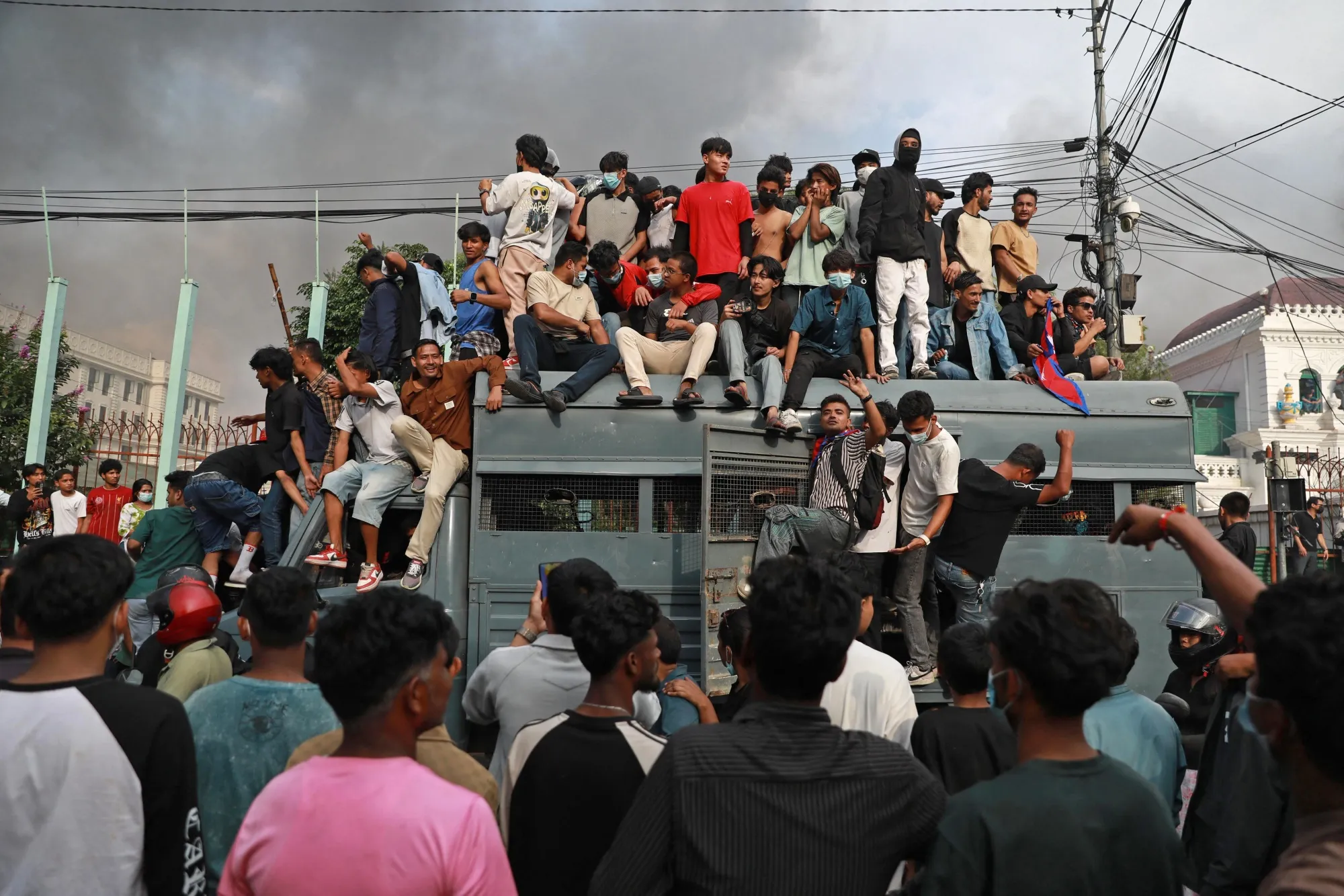 Protestors gather on a security vehicle outside the Singha Durbar, the main administrative building of the Nepal government, in Kathmandu on Sept. 9.