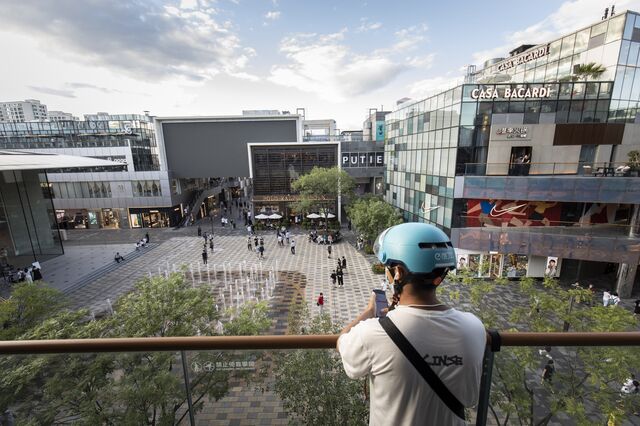 A food delivery driver waits to collect an order in an upscale retail area in Beijing, China, on Wednesday, Aug. 25, 2021. China's Communist Party vowed to promote the welfare of all people and redistribute income, underscoring its push to achieve "common prosperity" in the country.