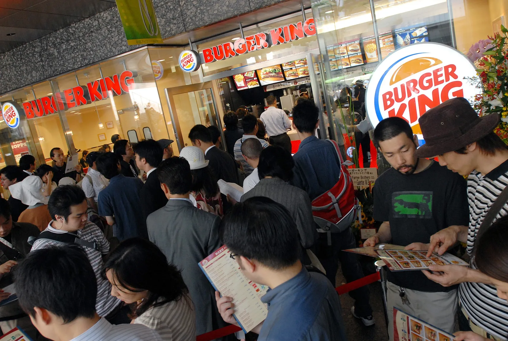 Customers wait in line outside a Burger King&nbsp;store in Tokyo, Japan