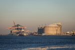 A container ship docked beyond storage tanks at a liquefied natural gas terminal at the Port of Rotterdam.