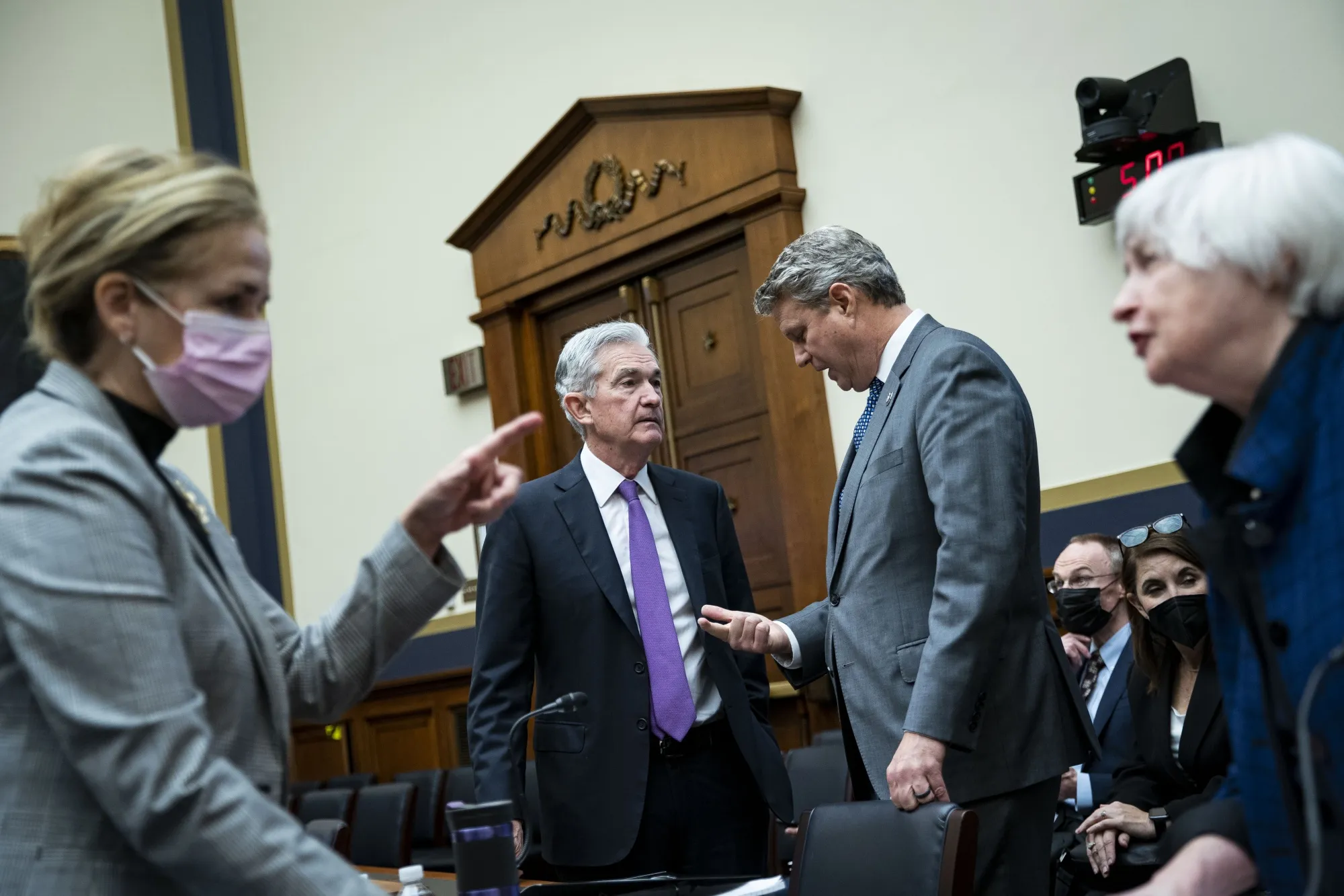 Jerome Powell, chairman of the U.S. Federal Reserve, second left, speaks to Representative Bill Huizenga, a Republican from Michigan, as Janet Yellen, U.S. Treasury secretary, right, speaks to Representative Madeleine Dean, a Democrat from Pennsylvania, left, following a House Financial Committee hearing in Washington, D.C., U.S., on Wednesday, Dec. 1, 2021. Stocks slid, short-term interest rates rose and measures of equity volatility surged Tuesday after the central bank chairman warned Congress that elevated inflation could justify ending asset purchases sooner than planned.