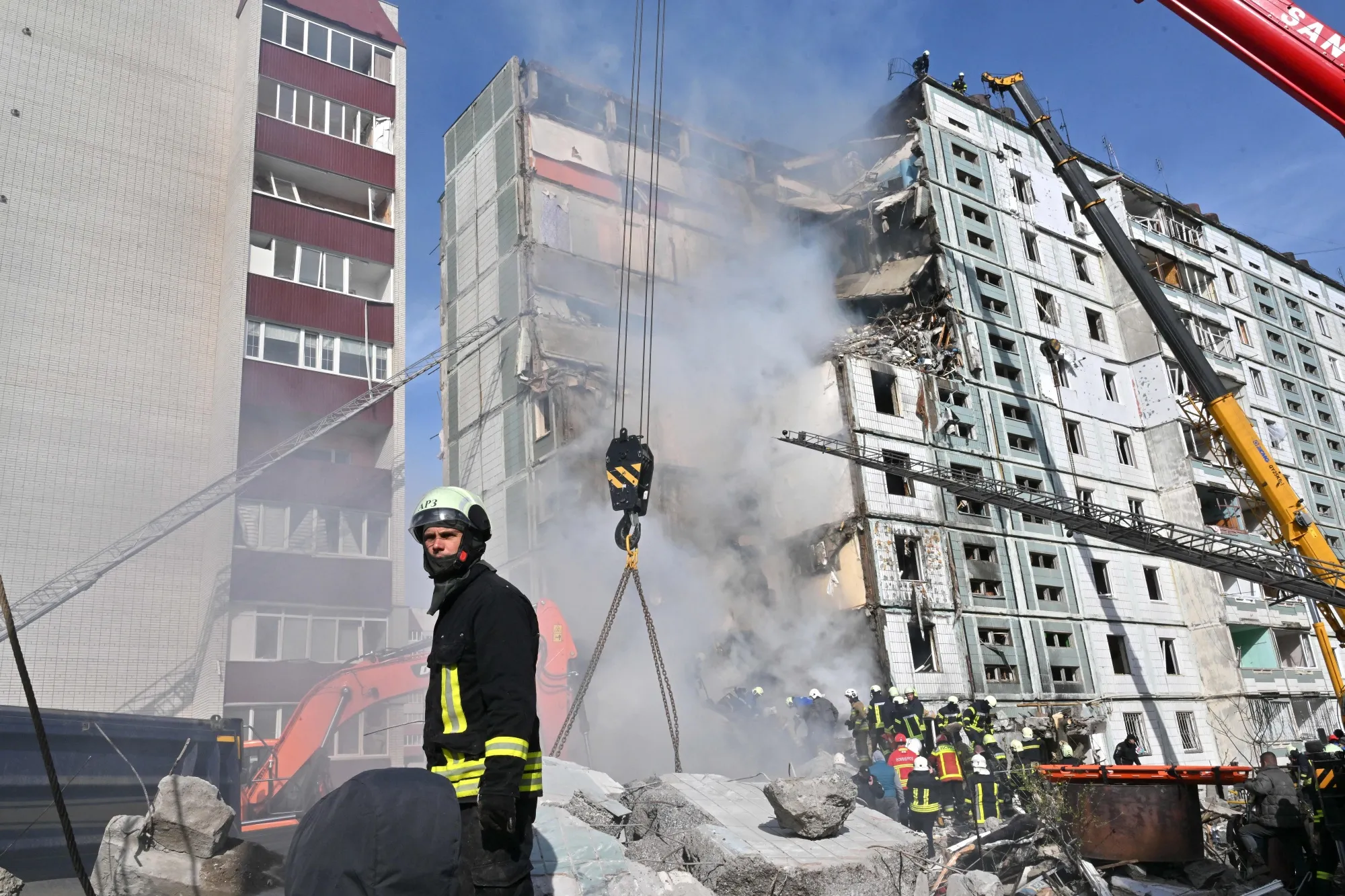 Rescuers search for survivors in the rubble next to a damaged residential building in Uman, on April 28.