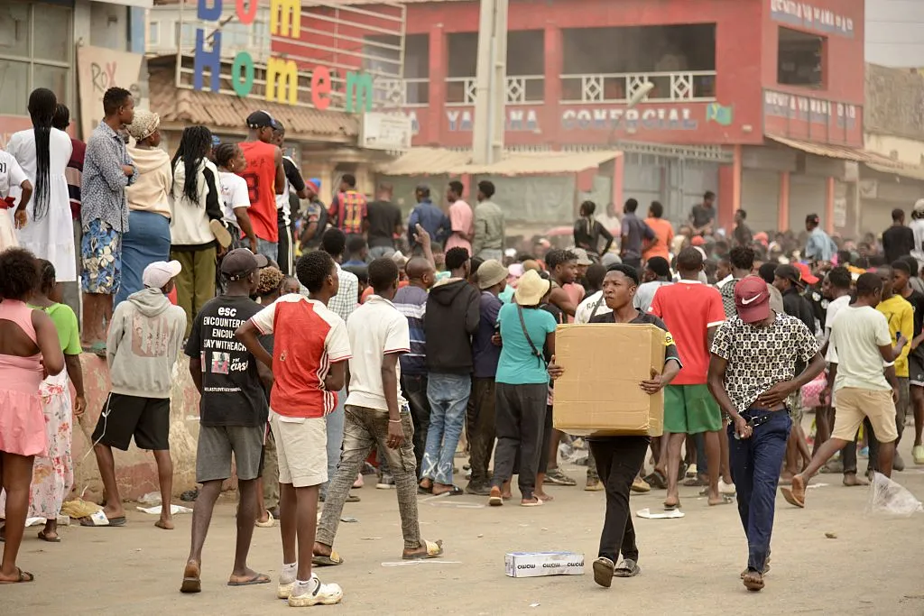 Residents carry items as looting erupts&nbsp;in the Kalemba 2 district of Luanda.