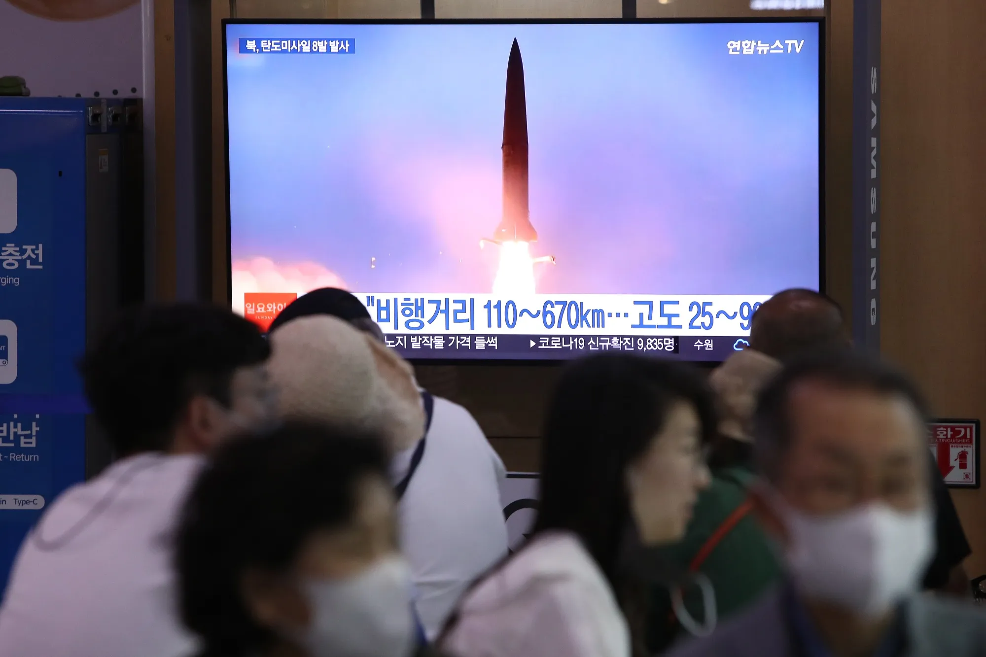 People in Seoul watch a broadcast showing a file image of a North Korean missile launch.