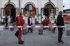 TOPSHOT - People wait in line at a safety distance to shop at the food market of Porta Palazzo in Turin on May 4, 2020.