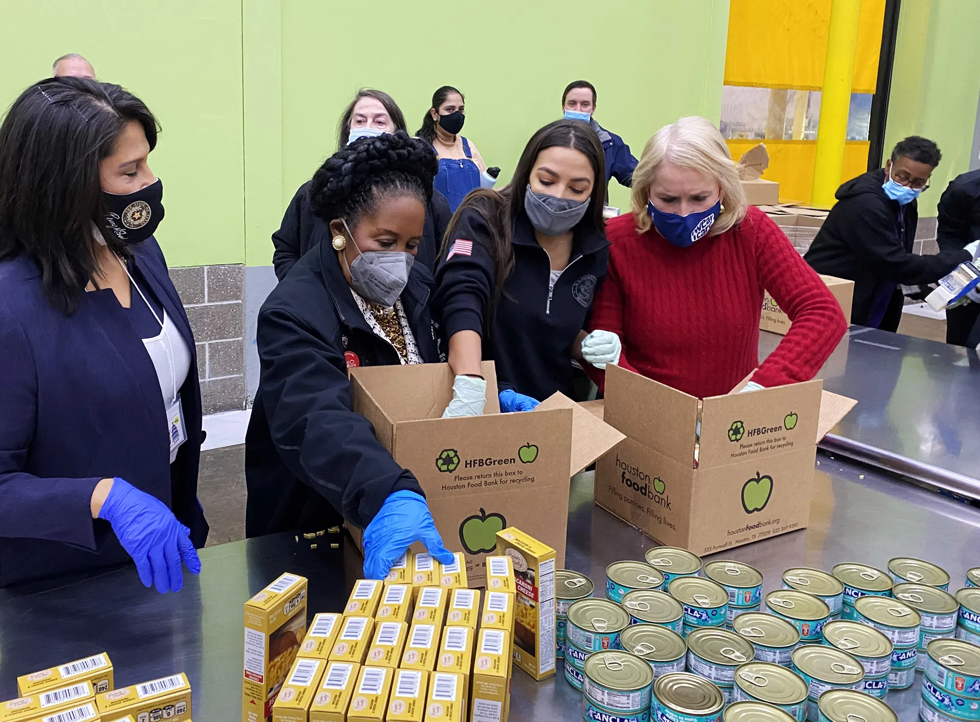 Alexandria Ocasio-Cortez boxes up food items at a Houston food bank, Feb. 20.