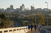 Pedestrians walk along a roadway back-dropped by commercial and residential buildings in the Sandton district of Johannesburg.