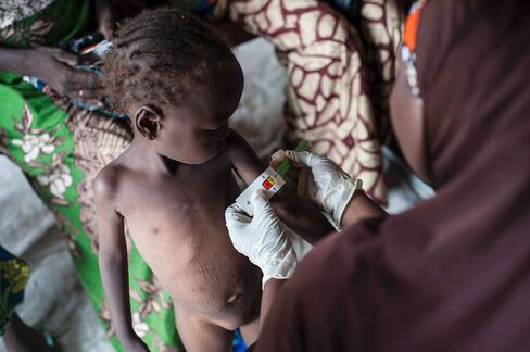 A woman measures the diameter of a girl’s arm suffering from severe acute malnutrition near Maiduguri.