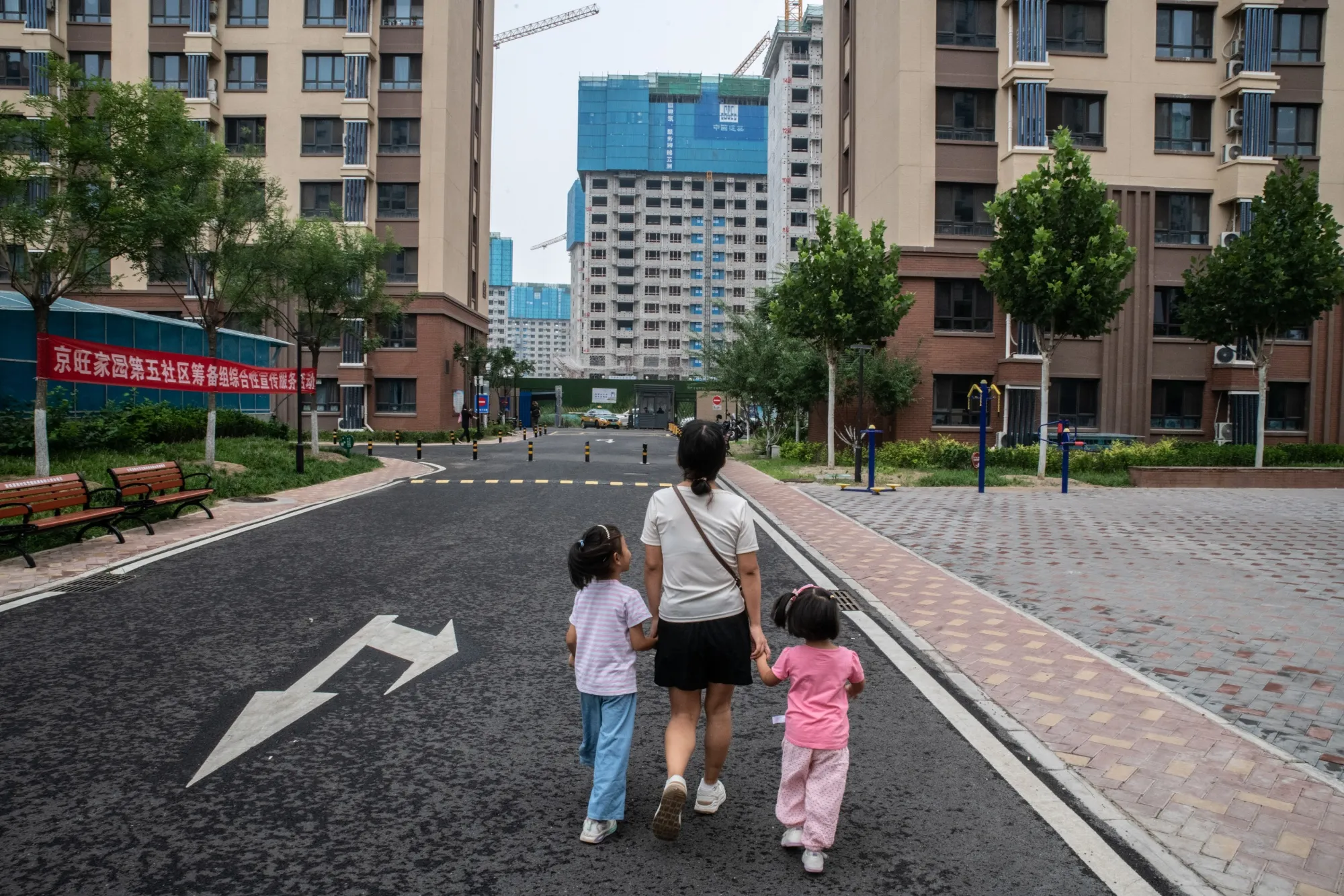 A woman walks with her children&nbsp;in Beijing.