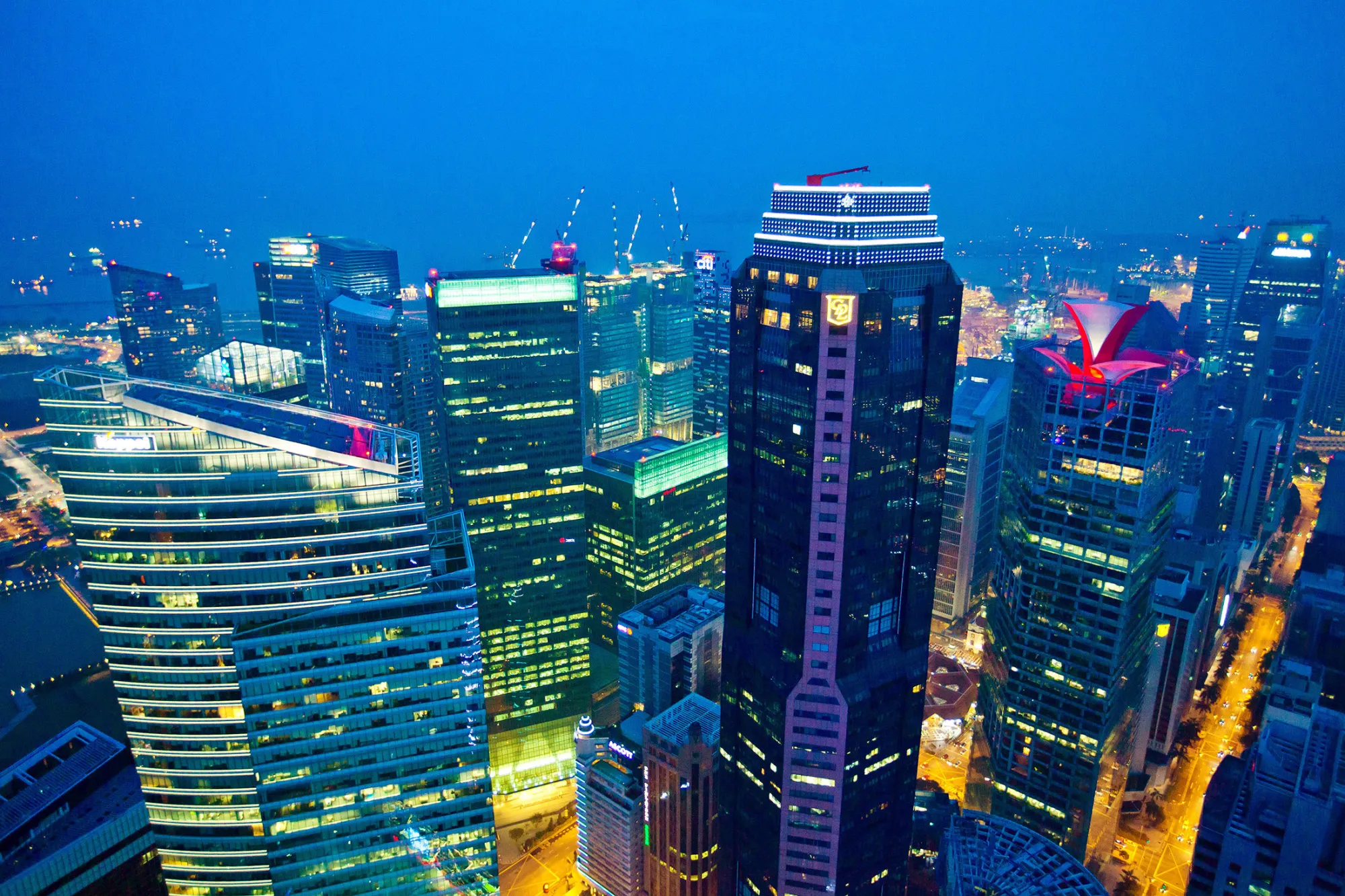 Commercial buildings stand illuminated at night in the central business district of Singapore, on Saturday April 9, 2016. Singapore edged past Hong Kong as the world's No. 3 financial center. The Southeast Asian city-state ranks behind London and New York on the Global Financial Centres Index, according to a survey by London-based research firm Z/Yen Group.
