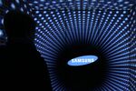 A visitor is silhouetted standing in front of the Samsung Electronics Co. logo displayed at the Semiconductor Rider experience at the company's d'light showroom in Seoul, South Korea, on Tuesday, Jan. 27, 2015. Samsung, the world's largest producer of smartphones using Google Inc.'s Android, is scheduled to release fourth-quarter earnings results on Jan. 29.