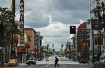 A man crosses the unusually quiet Hollywood Boulevard near the shuttered Pantages Theatre, on March 25.