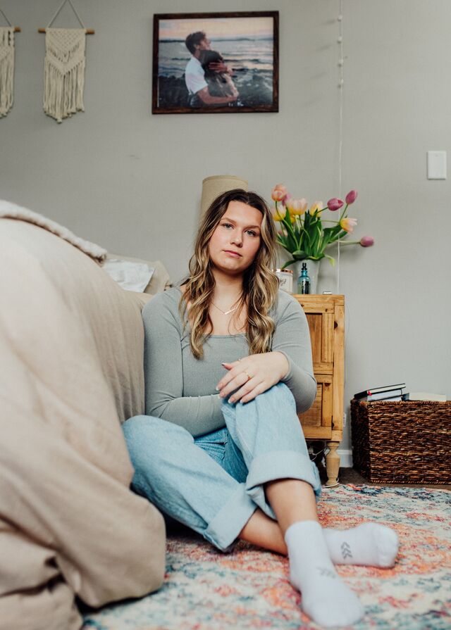 Kyla under a photo of the couple in her bedroom.