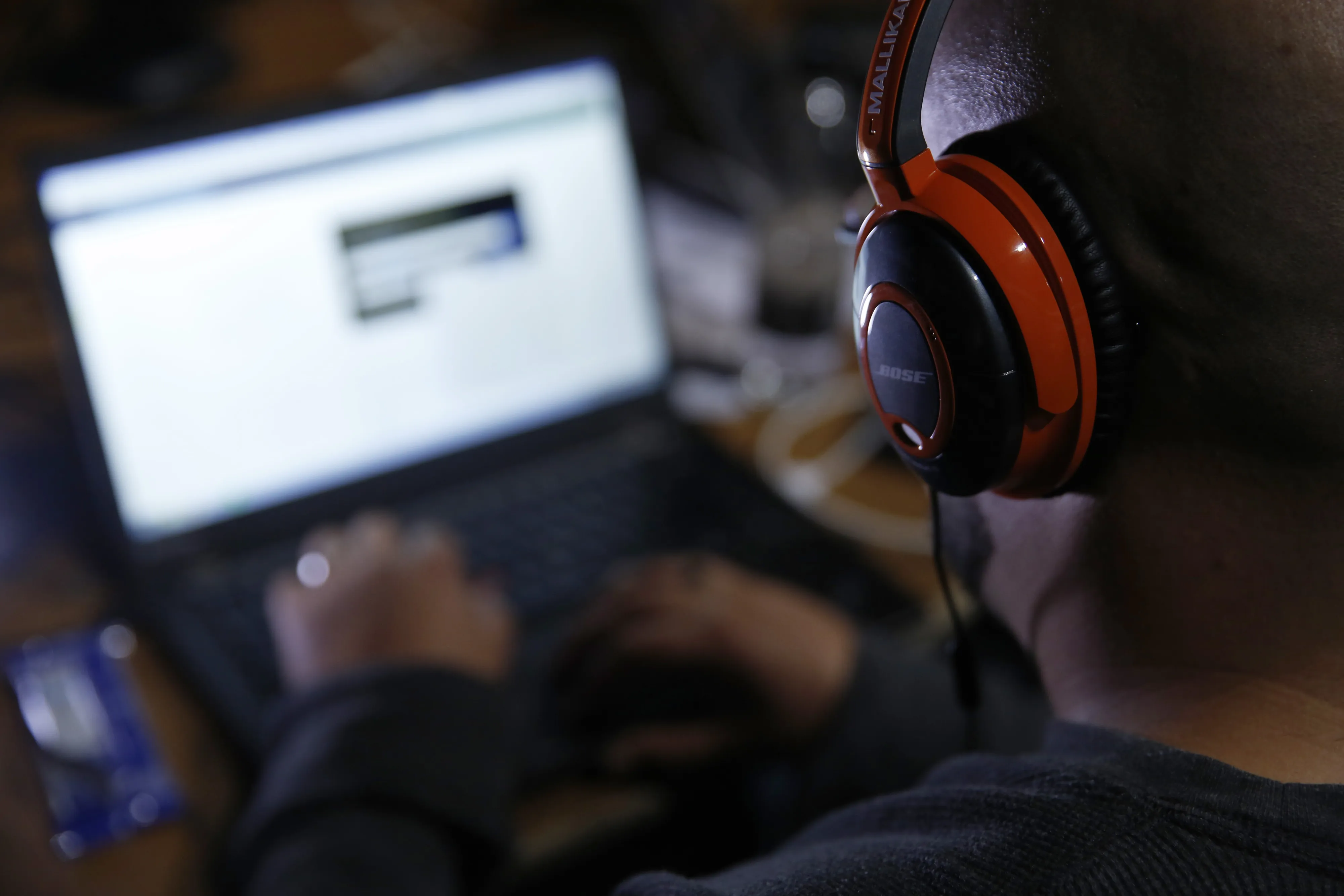 An attendee wearing Bose Corp. headphones works on a laptop computer as he participates in the TechCrunch Disrupt London 2015 Hackathon in London, U.K.