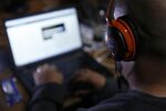 An attendee wearing Bose Corp. headphones works on a laptop computer as he participates in the TechCrunch Disrupt London 2015 Hackathon in London, U.K.
