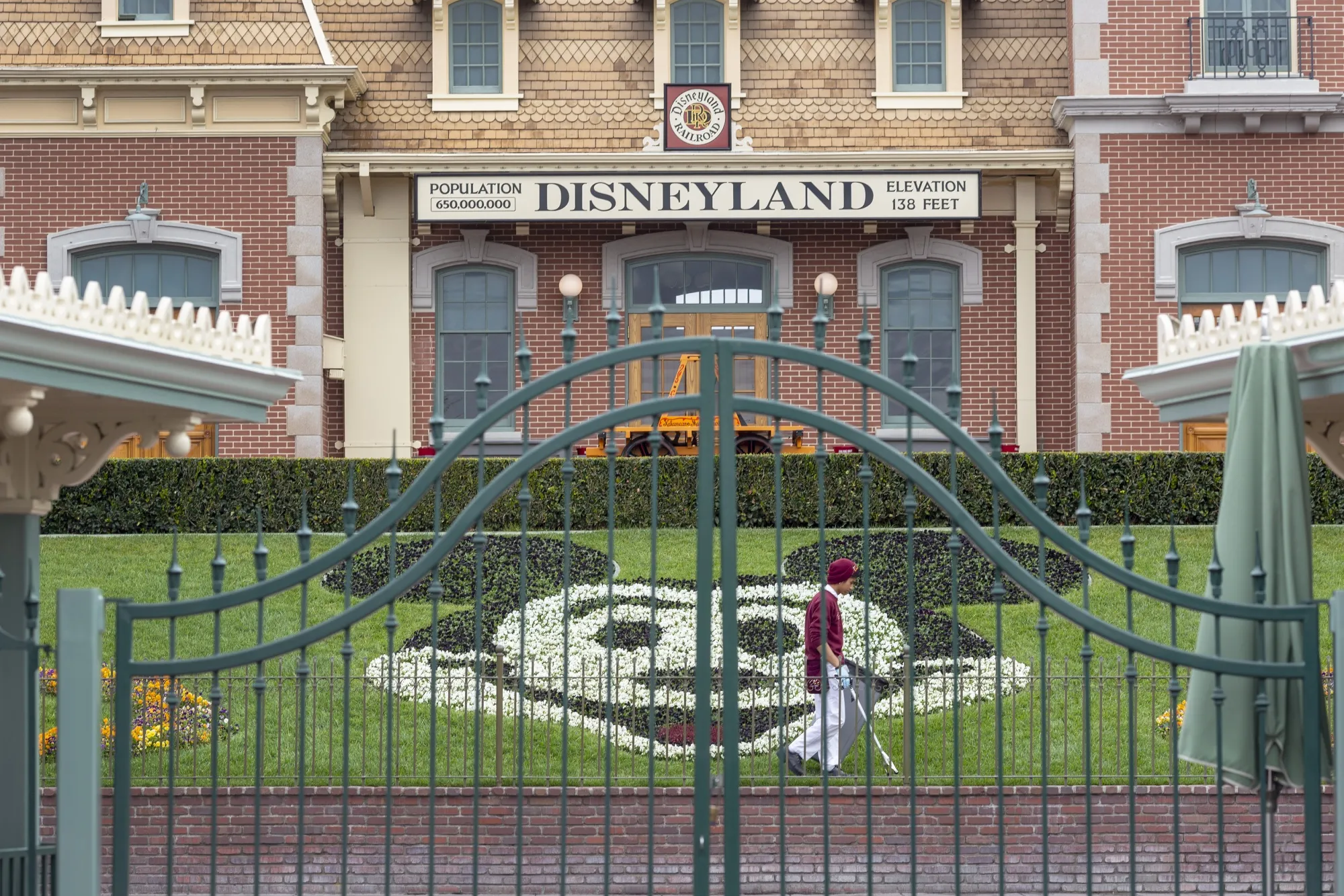 An employee cleans the grounds behind the closed gates of Disneyland Park&nbsp;in Anaheim, California, in March.