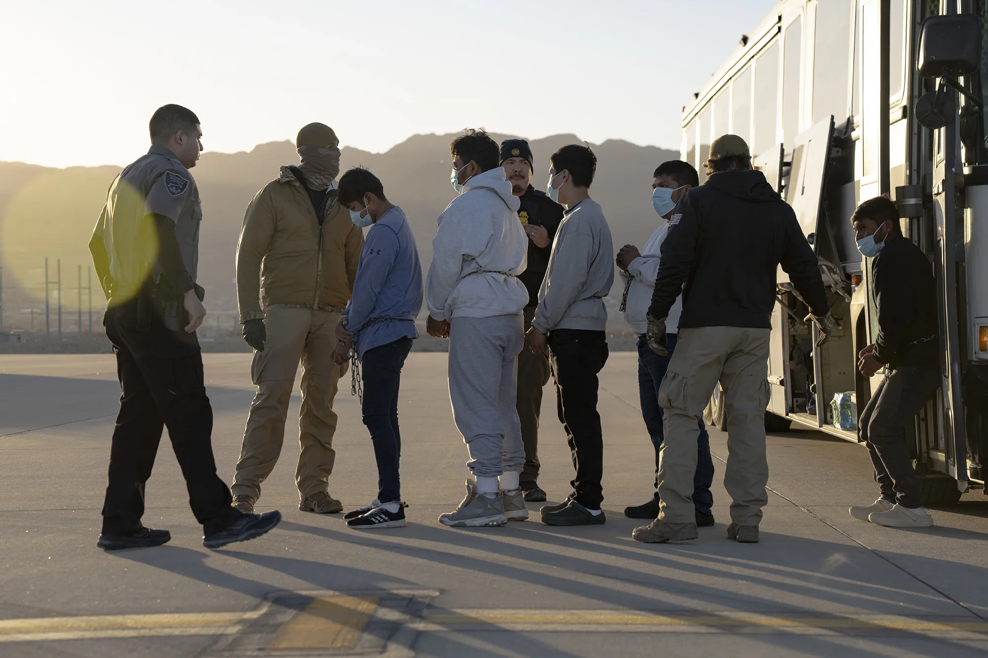 In an image&nbsp;provided by the US&nbsp;Department of Defense, US Customs and Border Protection security agents guide undocumented immigrants to&nbsp;a removal flight&nbsp;at Fort Bliss, Texas, on Jan. 23.&nbsp;
