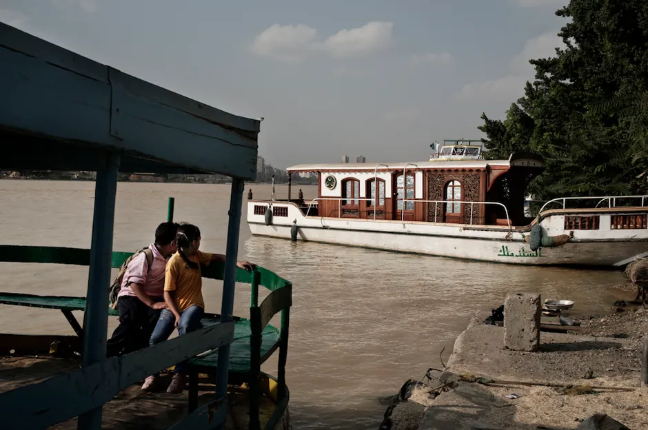 An Egyptian boy and girl sit on a ferry boat crossing from the city to Dahab Island on the Nile River.