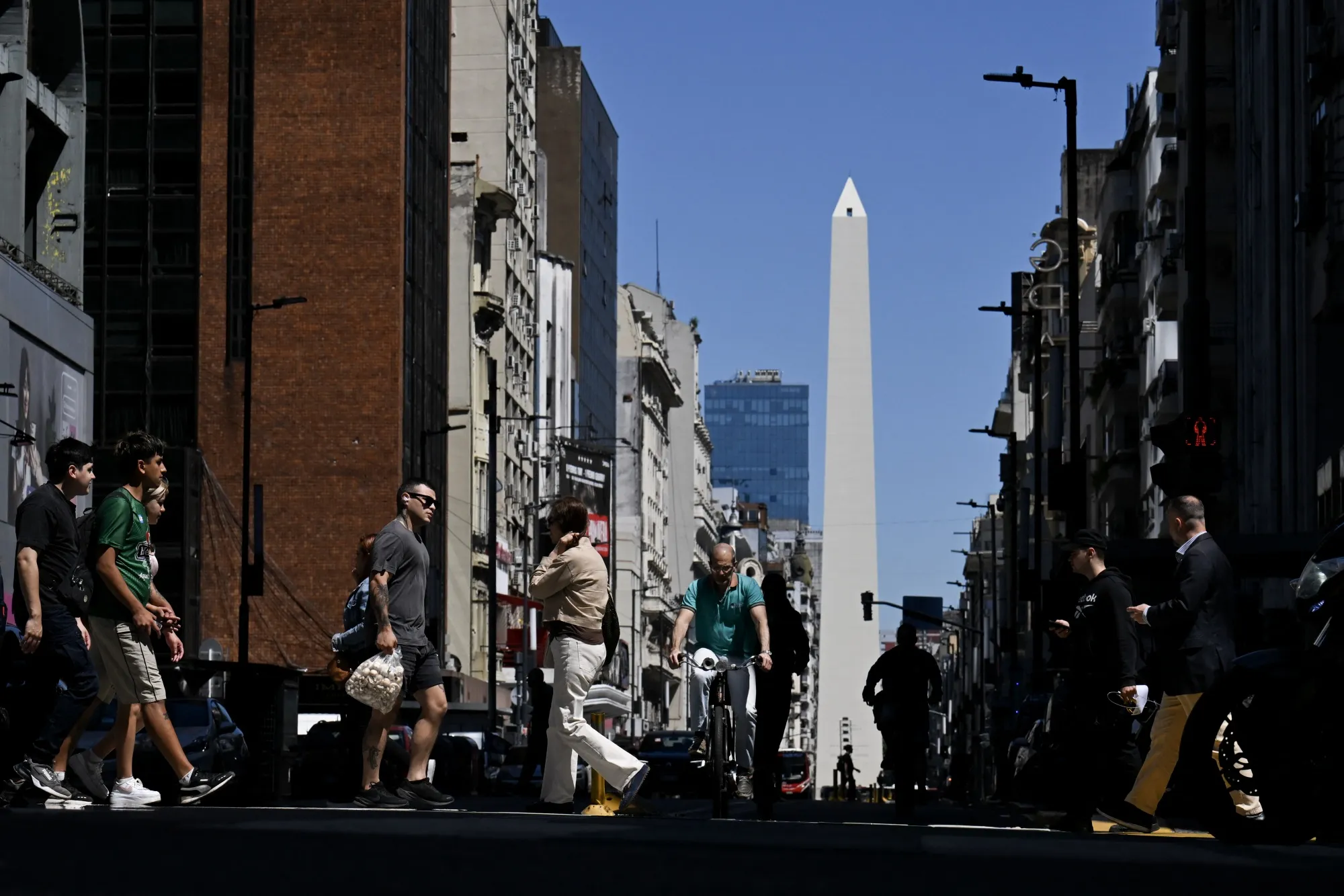 Peatones cruzan la Avenida Corrientes en Buenos Aires.